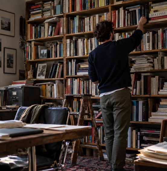 A reader browsing the shelves of a tall bookcase
